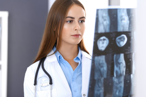 一位女医生站在医院窗户附近检查x光照片。在工作中的外科医生或整形外科医生医疗保健理念图片下载