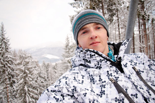 快乐的人在喀尔巴阡山脉的升降机上升起。以森林和滑雪场为背景。关闭了。冬天的本性。大雪落。图片下载