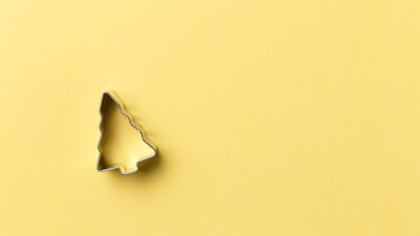 圣诞树曲奇切割机在黄色背景与复制空间。前视图。平的。时尚的彩色照片。以彩色纸为背景的简约风格。圣诞节的概念图片下载