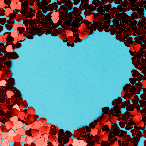 有创意的照片。情人节的明信片。情人节的背景。蓝色背景上的心形五彩纸屑。副本的空间。前视图。平的。柔和的颜色图片下载