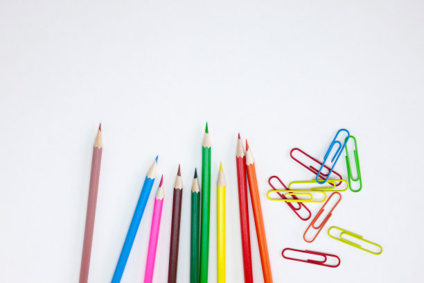 办公用品概念，彩色蜡笔和剪辑在白色的背景。图片下载
