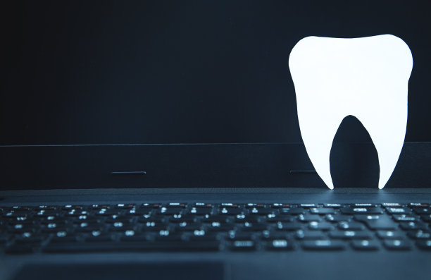 笔记本电脑键盘上的纸牙。医疗理念，在线牙科服务图片下载