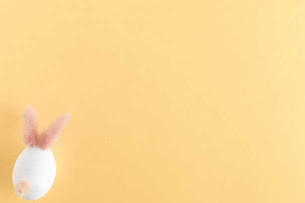 复活节彩蛋可爱的小兔子。黄色粉彩书桌背景上有趣的装饰。复活节快乐，俯视图，平躺图片下载