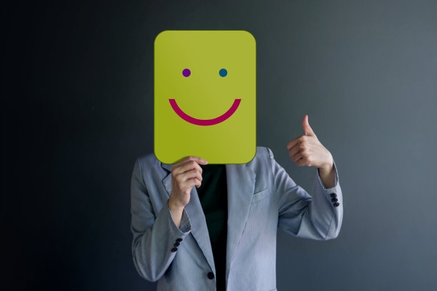 客户体验或人类情感概念。女人用纸遮住她的脸，用画线漫画和拇指向上的身体语言呈现快乐伟大的微笑图片下载