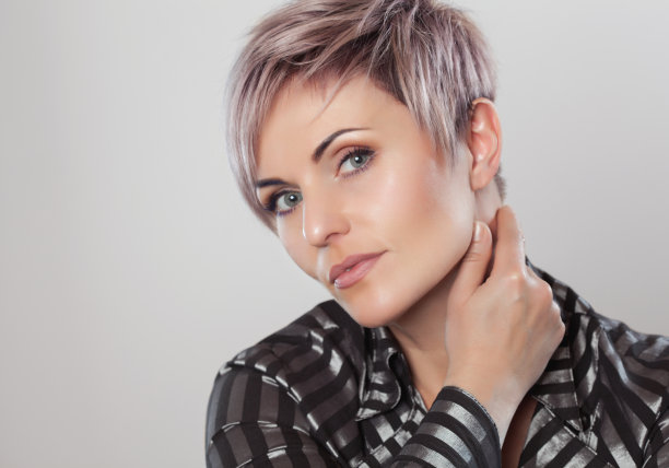 一个美丽的金发女人的肖像与美丽的化妆和短发后染发在美发沙龙。图片下载