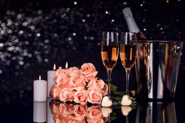 香槟酒瓶，两个酒杯，巧克力和玫瑰花束图片下载