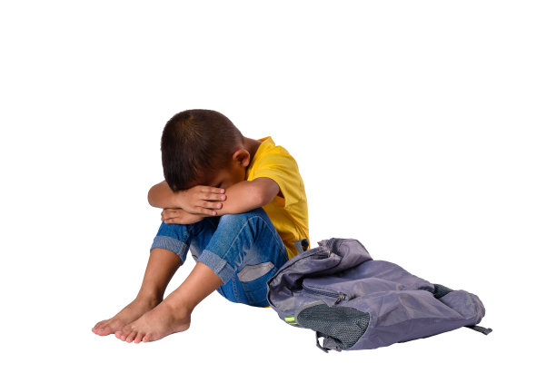 悲伤的亚洲小男孩坐在地板上背包孤立的白色背景图片下载