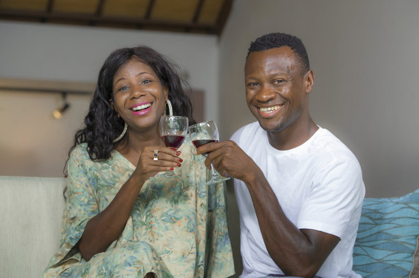 生活方式家庭肖像年轻浪漫和幸福的黑人美国黑人夫妇在客厅沙发上喝葡萄酒杯享受周年或情人节分享美丽的关系图片下载