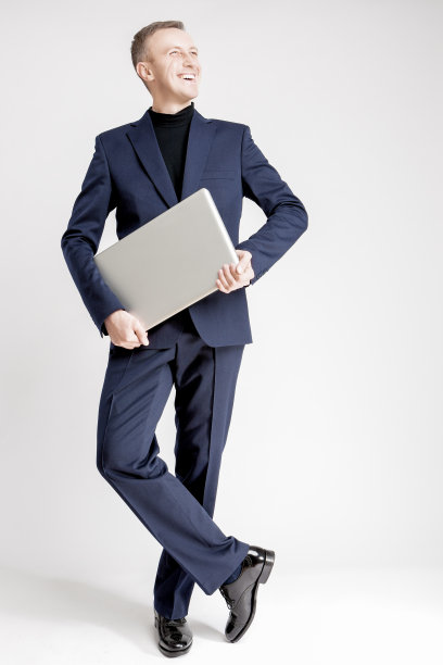 快乐和愉快的英俊的高加索商人与笔记本摆姿势的肖像图片下载
