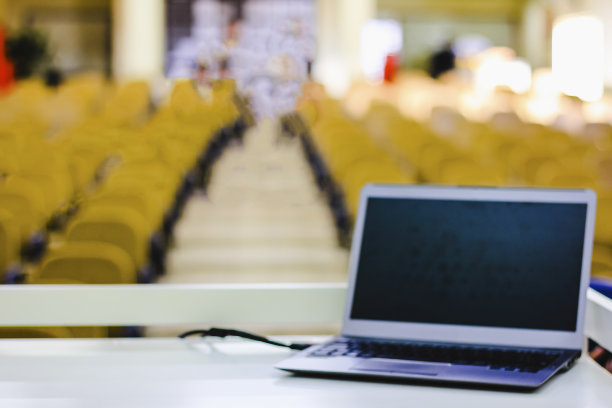 会议室里打开的笔记本电脑，背景是没有聚焦的椅子。有选择性的重点图片下载