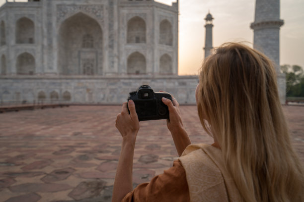 印度阿格拉，游客在日出时用相机拍摄著名的泰姬陵。亚洲人旅游概念图片下载