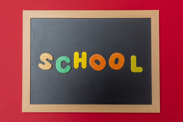 黑色的木框黑板，彩色的字学校，红色的墙背景图片下载
