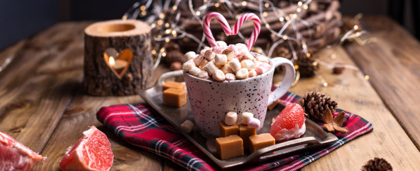 可可和棉花糖放在一个白色的杯子里，不同的圣诞糖果和糖果。照片在黑暗的风格和自由的文字空间。蜡烛和节日装饰品。图片下载