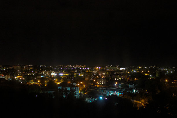 美妙的风景。夜晚城市的灯光。夜城在雾中成行。图片下载