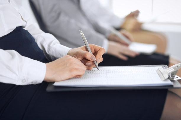 商务人士在办公室参加会议或培训，特写。女人坐在椅子上做笔记，就像排队或开会时一样。图片下载