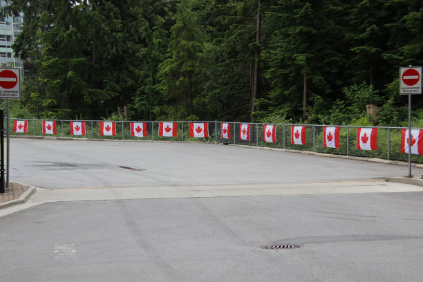 加拿大国旗挂在一排用铁链连接的栅栏上图片下载