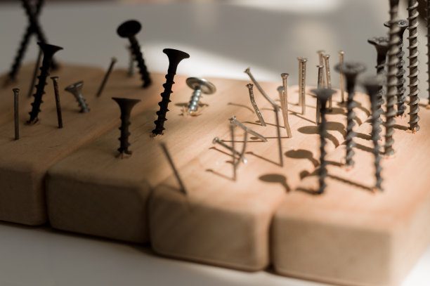 学习用螺丝刀工作。教授如何使用工具。概念上的照片。学习使用螺丝刀和锤子。许多螺丝和销钉。图片下载