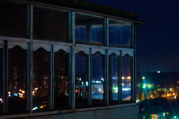 长曝光城市夜景照片。有窗户的阳台让夜晚城市的灯光透进来。图片下载