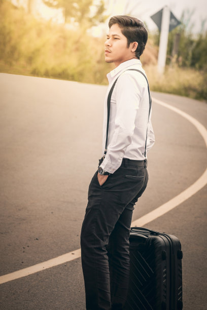 一个拿着箱子站在乡村路上等人图片下载
