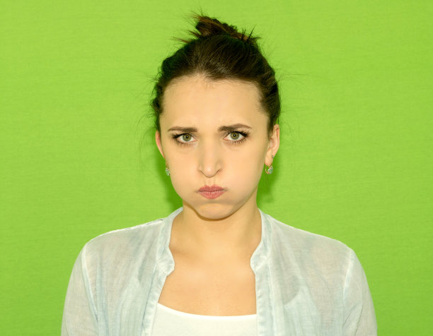 无聊的女人肖像。孤立在绿色背景上。图片下载