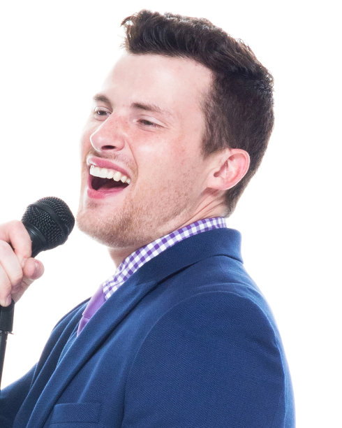 帅小伙拿着麦克风唱歌图片下载