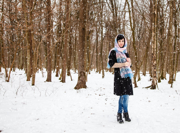 一个年轻女子在冬季公园散步图片下载