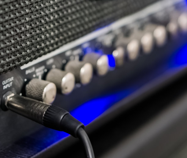 宏观特写的吉他电缆，插入放大器，专业音乐设备图片下载