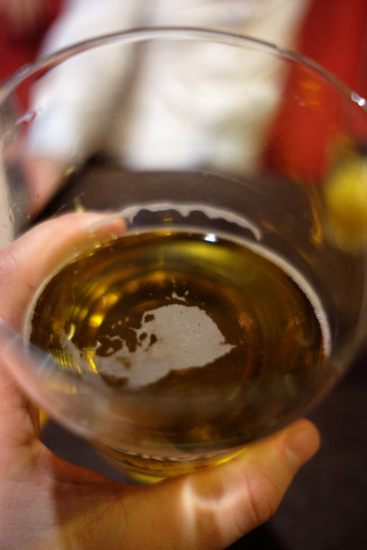 男人手里拿着一杯啤酒，然后抿了一口图片下载