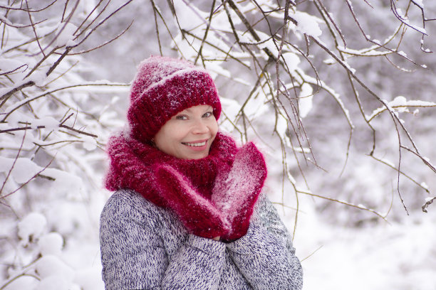 戴着红帽子和围巾的女孩在冬天的公园里玩图片下载