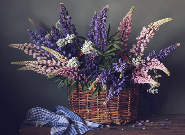 桌上放着一篮紫色和粉色的羽扇豆。图片下载