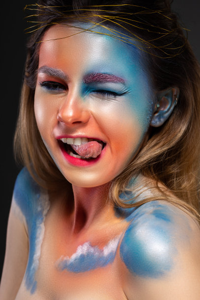 云朵被画在模特的脸上。女孩与创造性的化妆。图片下载
