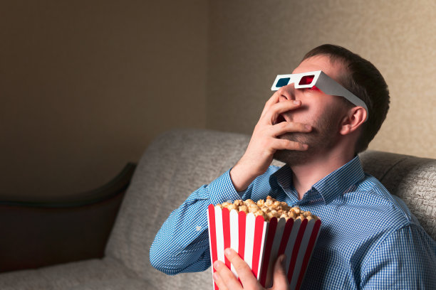 惊讶的男人拿着爆米花看电影图片下载