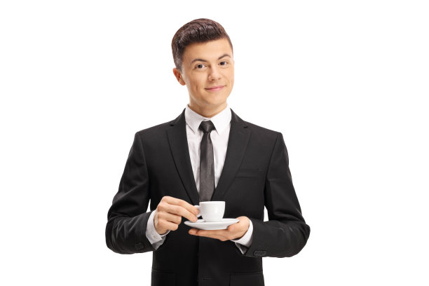 穿着西装的年轻人拿着咖啡杯，看着镜头图片下载