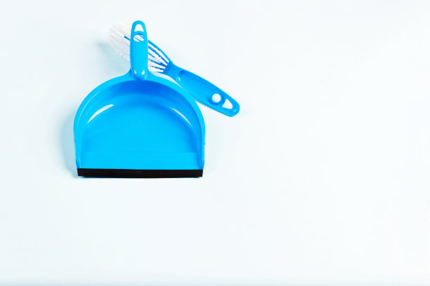 春季清洁，蓝色塑料簸箕和刷子，近距离上的蓝色背景图片下载