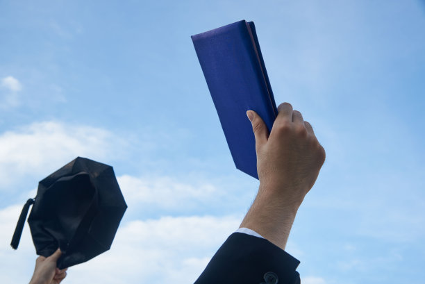 毕业生举起学位和学位帽图片下载