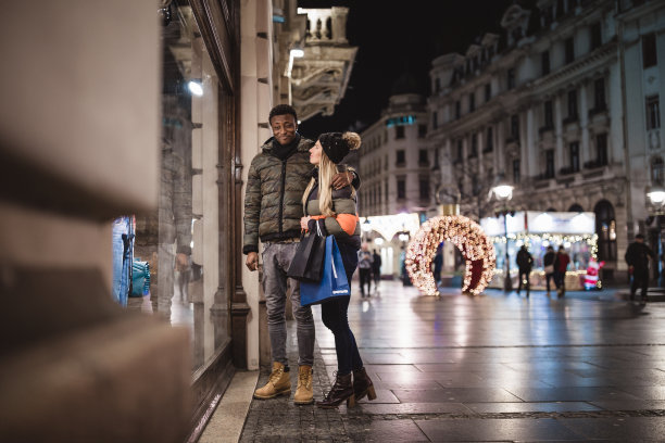 年轻夫妇在户外享受圣诞购物。图片下载