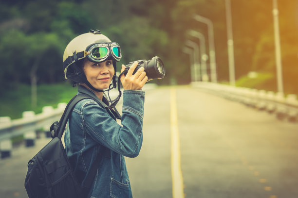 女摄影师游客拿着相机，在街道和山上拍摄美丽的自然图片下载