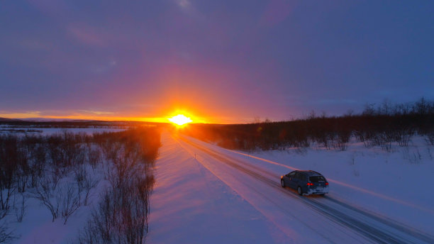图片:一辆越野车行驶在白雪覆盖的森林道路上图片下载
