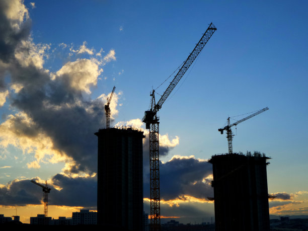 建筑起重机。住宅或公寓建筑。日落剪影照片。图片下载