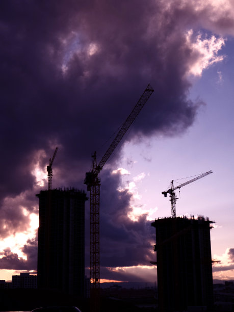 建筑起重机。住宅或公寓建筑。日落剪影照片。图片下载