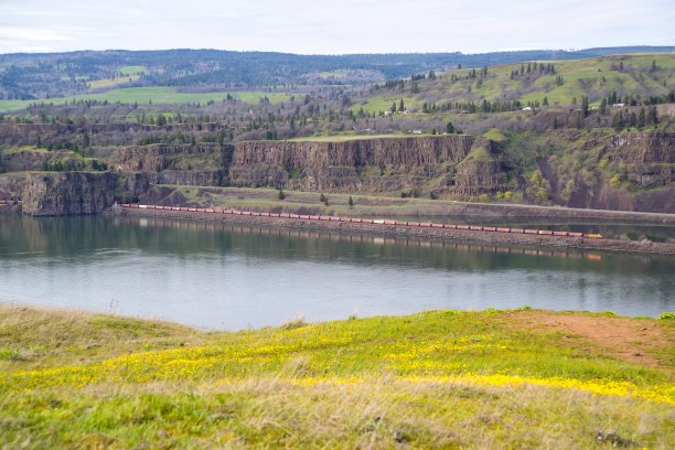 一列货运列车在美国华盛顿哥伦比亚河旁的铁路上行驶图片下载