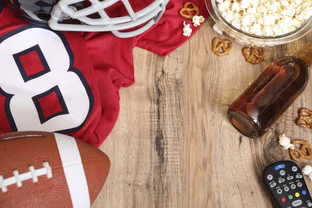 一边看足球比赛一边吃零食，喝饮料。图片下载