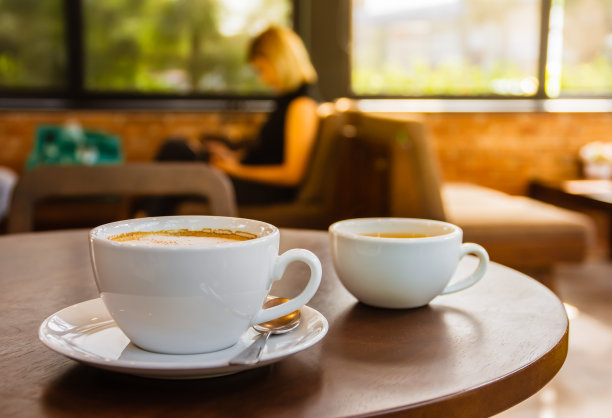 热阿拉比卡拿铁咖啡和热茶的白色杯子在咖啡店早上点心。图片下载