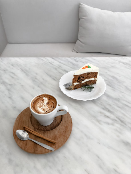 俯视图热拿铁咖啡和胡萝卜蛋糕在木制托盘上的大理石桌子图片下载