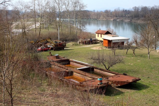 两艘锈迹斑斑的内河驳船和其他设备紧靠内河图片下载