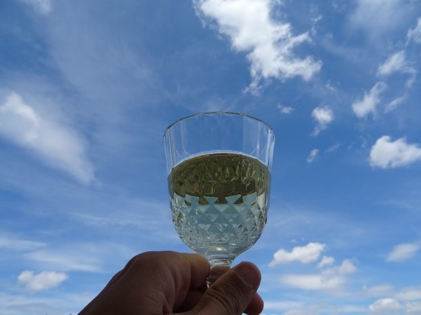 一杯酒，蓝天白云为背景图片下载