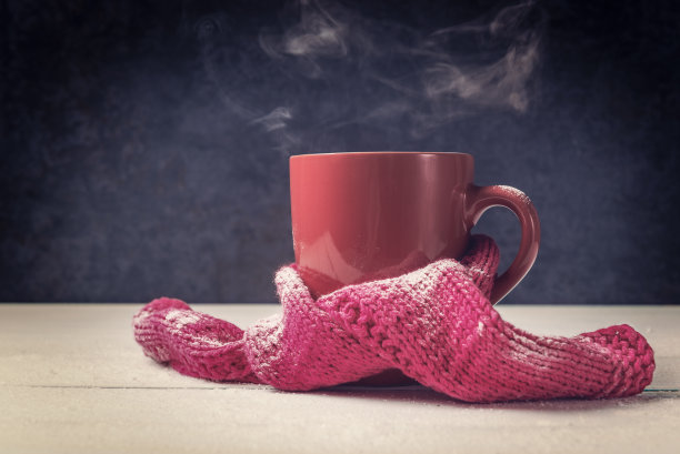 一杯热饮料在粉红色的杯子和围巾图片下载