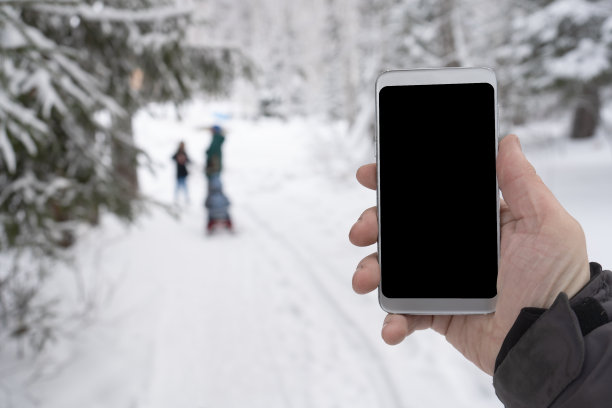 冬日雪林里男人手里的电话图片下载