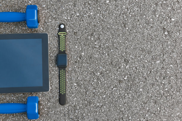 聪明的体育产品。裁剪照片的智能手表，水和黑色运动鞋图片下载