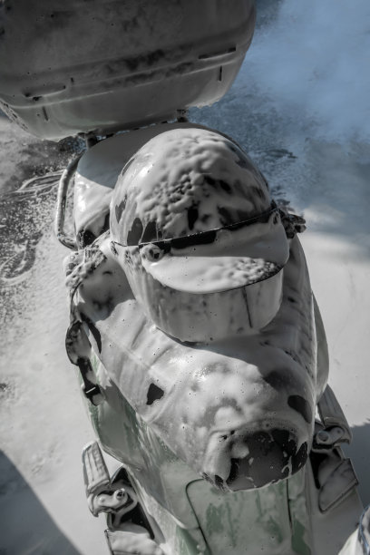 摩托车头盔特写，用肥皂清洗。黑色的头盔上覆盖着泡沫。图片下载